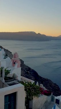 Sunset in Oia Santorini Greece during summer. whitewashed building and church during sunset in Greece