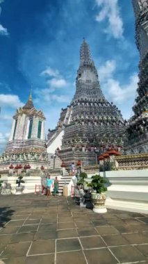 Wat Arun Şafak Tapınağı Bangkok, Tayland 'da öğleden sonra. Asyalı kadın ve Avrupalı erkekler Bangkok 'taki Wat Arun tapınağını ziyaret ediyorlar.