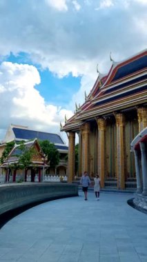 Wat Ratchabophit, Tayland 'ın başkenti Bangkok' ta bir kraliyet tapınağı. Şapkalı birkaç Asyalı kadın ve Bangkok 'taki bir tapınağı ziyaret eden Avrupalı erkekler.