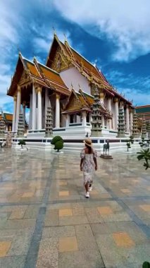 Wat Suthat Thepwararam Ratchaworahawihan is the royal temple in the capital city of Bangkok, Thailand. Asian woman with hat walking at a temple in Bangkok