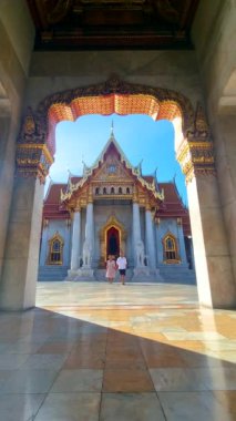 Wat Benchamabophit the marble temple, is a royal temple in the capital city of Bangkok, Thailand. couple Asian women with hat and European men visiting a temple in Bangkok