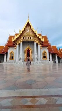 Wat Benchamabophit the marble temple, is a royal temple in the capital city of Bangkok, Thailand. Asian woman with hat visiting a temple in Bangkok