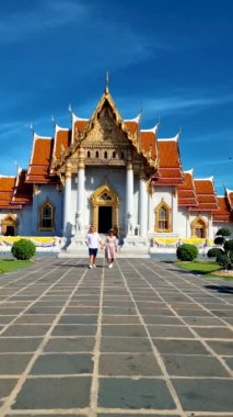 Wat Benchamabophit the marble temple, is a royal temple in the capital city of Bangkok, Thailand. couple Asian women with hat and European men visiting a temple in Bangkok