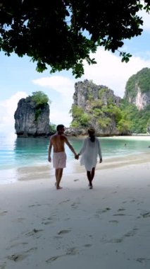Koh Hong Adası Krabi Tayland, Tayland 'da tropik bir plajda birkaç kadın ve erkek. Tayland 'da kumsalda yürüyen bir çiftin ağır çekimleri.