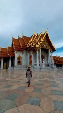 Wat Benchamabophit the marble temple, is a royal temple in the capital city of Bangkok, Thailand. Asian woman with hat visiting a temple in Bangkok