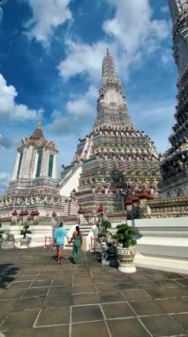 Wat Arun Şafak Tapınağı Bangkok, Tayland 'da öğleden sonra. Asyalı kadın ve Avrupalı erkekler Bangkok 'taki Wat Arun tapınağını ziyaret ediyorlar.