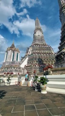 Wat Arun Şafak Tapınağı Bangkok, Tayland 'da öğleden sonra. Asyalı kadın ve Avrupalı erkekler Bangkok 'taki Wat Arun tapınağını ziyaret ediyorlar.