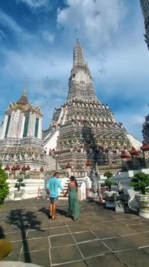 Wat Arun Şafak Tapınağı Bangkok, Tayland 'da öğleden sonra. Asyalı kadın ve Avrupalı erkekler Bangkok 'taki Wat Arun tapınağını ziyaret ediyorlar.