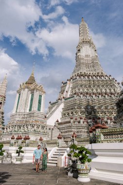 Wat Arun tapınağı Bangkok Tayland, Şafak Tapınağı, Budist tapınağı Chao Phraya Nehri 'nin yanında. Güzel Wat Arun akşam üstü, Bangkok' taki tapınağı ziyaret eden birkaç Asyalı kadın ve Avrupalı erkek.
