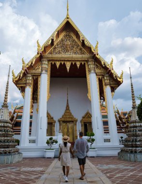Bangkok Tayland 'daki Wat Pho tapınağı, Bangkok' taki yaslanan tapınak. Güneşli bir günde güzel bir Budist tapınağı, birkaç Asyalı kadın ve Avrupalı erkek Bangkok 'u ziyaret ediyor