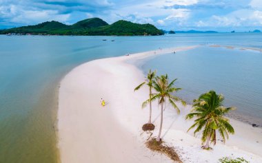 Ada Koh Yao Tayland 'da kumsalda yürüyen bir çift kadın ve erkek. Beyaz kum ve palmiye ağaçları olan bir kumsal..