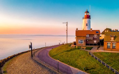 Urk Flevoland Netherlands sunset at the lighthouse and harbor of Urk Holland. Fishing village Urk. Beautiful sunset drone aerial view