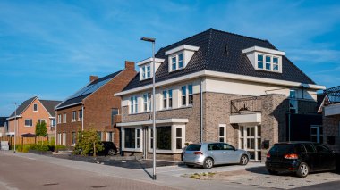 Newly build houses with solar panels attached on the roof against a sunny sky Close up of a new building with black solar panels. Zonnepanelen, Zonne energie, Translation: Solar panel, , Sun Energy. 