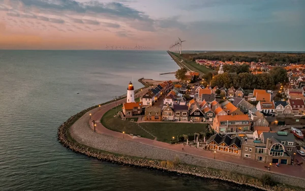 Urk Flevoland Netherlands sunset at the lighthouse and harbor of Urk Holland. Fishing village Urk. Beautiful sunset drone aerial view