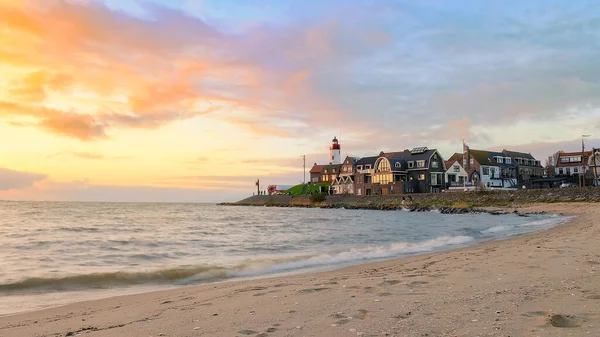 Urk Flevoland Netherlands sunset at the lighthouse and harbor of Urk Holland. Fishing village Urk. Beautiful sunset drone aerial view