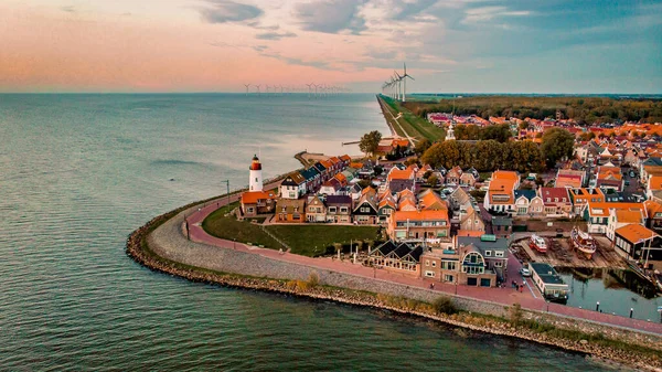 Urk Flevoland Netherlands sunset at the lighthouse and harbor of Urk Holland. Fishing village Urk. Beautiful sunset drone aerial view