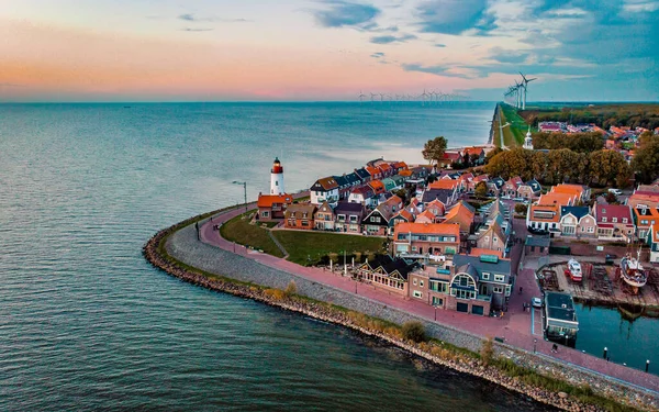 Urk Flevoland Netherlands sunset at the lighthouse and harbor of Urk Holland. Fishing village Urk. Beautiful sunset drone aerial view