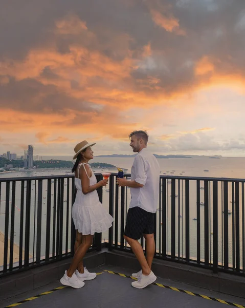 couple of men and women on a rooftop bar in Pattaya,, View from the terrace of the Hilton Sky Bar at sunset. Pattaya rooftop bar Thailand.