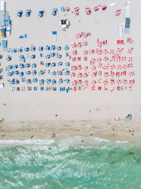 Drone aerial view at Miami South Beach Florida. Beach with colorful chairs and umbrellas, top view of the beach Miami Florida