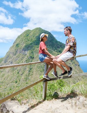 couple hiking in the mountains of Saint Lucia Caribbean, nature trail in the jungle of Saint Lucia with a look at the huge Pitons. 