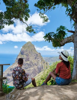 couple hiking in the mountains of Saint Lucia Caribbean, nature trail in the jungle of Saint Lucia with a look at the huge Pitons. 