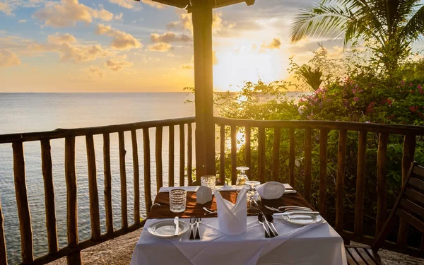 dinner table during sunset, romantic dinner by the ocean watching the beautiful Caribbean ocean. beautiful sunset in the caribbean sea