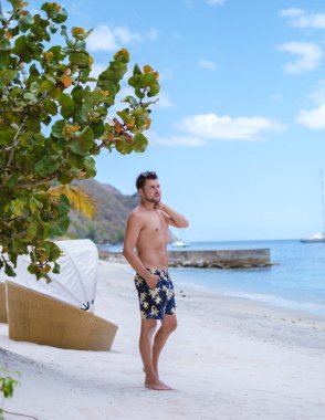 young men in a swim short on vacation in Saint Lucia, luxury holiday Saint Lucia Caribbean, men on vacation at the tropical Island of Saint Lucia Caribbean. sugar beach St Lucia Caribbean