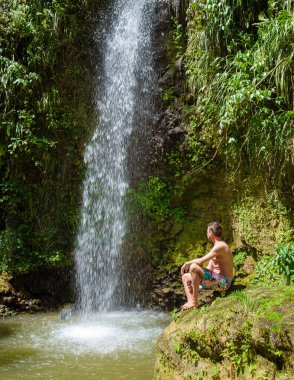 Young men relaxing at Toraille waterfall St Lucia. Saint Lucia jungle waterfall and men swimming. Toraille Falls Sain Lucia