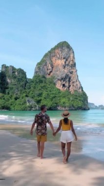 Caucasian men and Asian woman walking on a tropical beach in Thailand, Railay Beach Krabi Thailand, Asian women and European men walking on the beach in the morning,