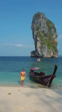 European men on tropical beaches in Thailand, tourists walking on a white tropical beach of Koh Poda Thailand. men on tropical Koh Poda beach in Krabi Thailand, white tropical beach of Koh Poda