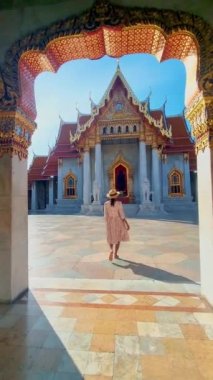 Wat Benchamabophit the marble temple, is a royal temple in the capital city of Bangkok, Thailand. Asian women with hat visiting the marble temple in Bangkok