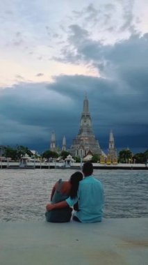 Wat Arun The Temple of Dawn Landmark of Bangkok, Thailand during the afternoon in Bangkok. Asian woman and European men visiting Wat Arun temple in Bangkok during vacation in Thailand