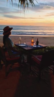 Women having dinner on the beach in Thailand, Luxuryromantic dinner with candlelight during sunset, luxury travel, and lifestyle. 