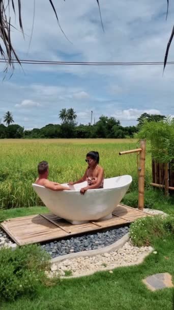 Couple Men Women White Bathtub Looking Out Green Rice Field — Video Stock