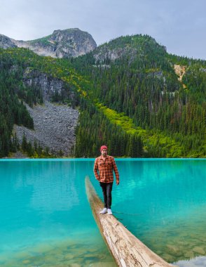 Joffre Lakes British Colombia Whistler Canada, colorful lake of Joffre lakes national park in Canada. Young men with hat visiting Joffre lake
