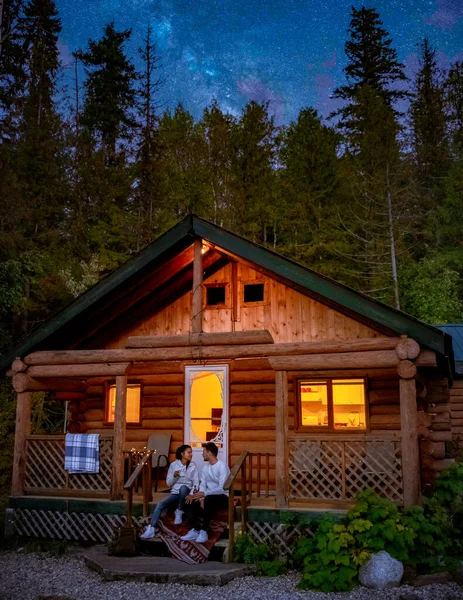 Wooden hut in an autumn forest, cabin off the grid, wooden cabin circled by colorful yellow and red fall trees. cabin in the woods British Colombia Canada Autumn. Couple men and women on vacation in