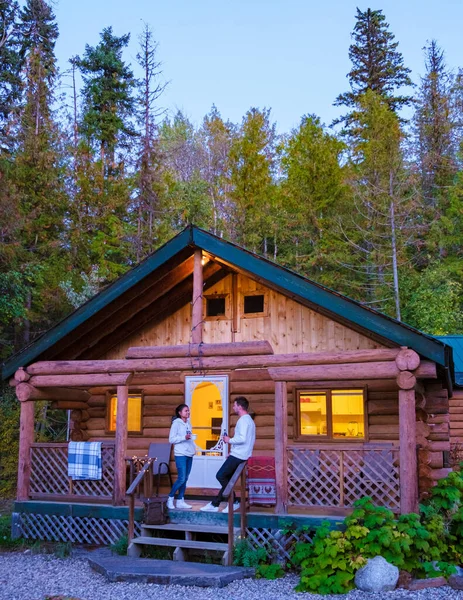 Wooden hut in an autumn forest, cabin off the grid, wooden cabin circled by colorful yellow and red fall trees. cabin in the woods British Colombia Canada Autumn. Couple men and women on vacation in