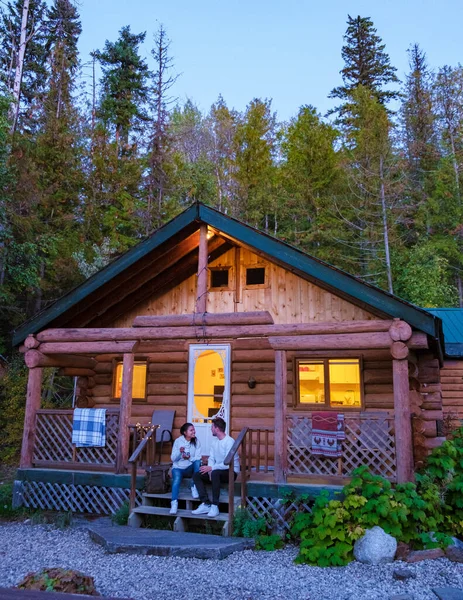 Wooden hut in an autumn forest, cabin off the grid, wooden cabin circled by colorful yellow and red fall trees. cabin in the woods British Colombia Canada Autumn. Couple men and women on vacation in