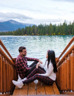 couple at Beauvert lake, sunrise by the lake at Jasper, Lac Beauvert Alberta Canadian Rockies Canada. men and women watching the sunrise by the lake in Jasper Canada