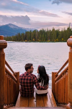 couple at Beauvert lake, sunrise by the lake at Jasper, Lac Beauvert Alberta Canadian Rockies Canada. men and women watching the sunrise by the lake in Jasper Canada