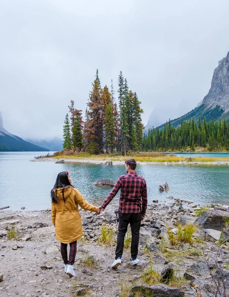 Spirit Island in Maligne Lake, Jasper National Park, Alberta, Canada. The Canadian Rockies. Asian women and caucasian men visit Maligne lake during the autumn and fall season