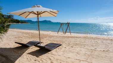 Beach chairs on the beach of Ban Amphur Beach Pattaya Thailand, a beach with beautiful palm trees and a blue ocean in Pattaya Thailand