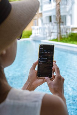 women hand with a phone checking commodity prices on her cellphone 