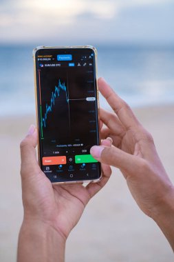 Asian women with checking Eur Usd currency on their phones when on holiday, women check Euro and USD their phone on vacation 