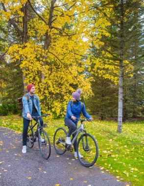 men and women on a bike bicycle in Canada Canadian Rockies during Autumn fall season. 