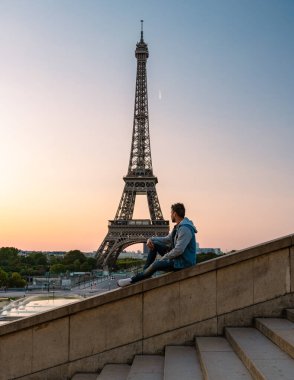 Young men watching sunrise by the Eiffel tower, Eiffel tower at Sunrise in Paris France, Paris Eifel tower on a summer day in the city of Paris France