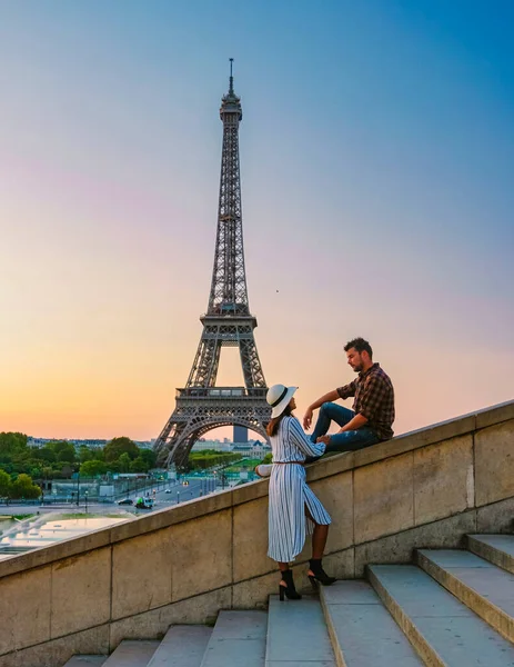 Eiffel tower at Sunrise in Paris France, a Young couple in a city trip by Eiffel tower at Sunrise, man woman in love, valentine concept in Paris the city of love