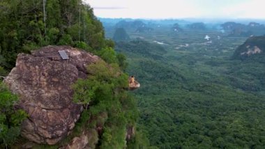 Dragon crest rock in the jungle of Krabi Thailand, couple men and woman looking out over the jungle. Dragon Crest or Khuan Sai at Khao Ngon Nak Nature Trail in Krabi