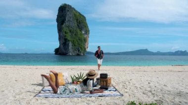 Koh Poda Krabi Thailand, an Asian woman, and a European man are having a picnic on the tropical beach of Koh Poda Island Krabi Thailand. 