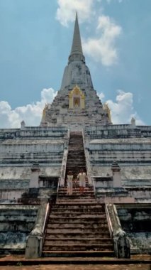 Wat Phu Khao Thong chedi in Ayutthaya, Thailand. White pagoda, couple men and women on a trip to Ayutthaya visit the white pagoda temple